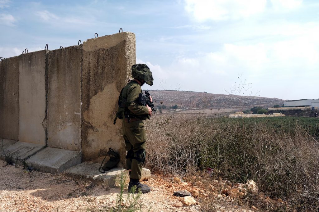 An Israeli soldier looks out at Lebanon from the Israeli side of Israel's border with Lebanon in northern Israel, October 8