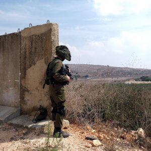 An Israeli soldier looks out at Lebanon from the Israeli side of Israel's border with Lebanon in northern Israel, October 8