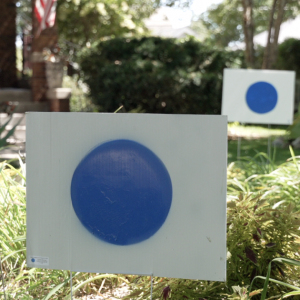 Yard sign with blue dot against white background